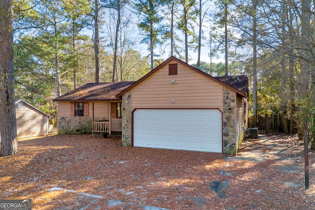 ranch-style house featuring a garage and central AC unit