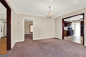 unfurnished room with dark colored carpet, plenty of natural light, and ornamental molding