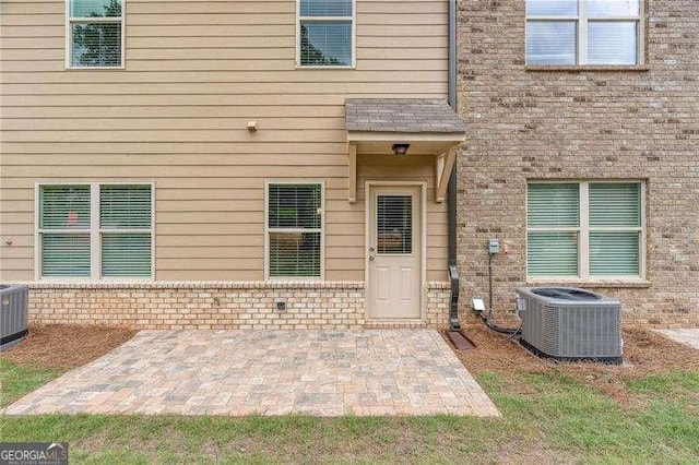 entrance to property with a patio and central air condition unit