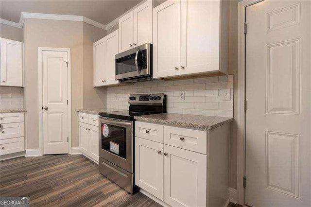 kitchen featuring ornamental molding, appliances with stainless steel finishes, dark hardwood / wood-style flooring, light stone countertops, and white cabinets