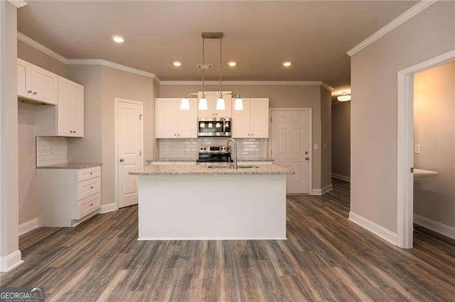 kitchen featuring white cabinetry, appliances with stainless steel finishes, an island with sink, and light stone counters