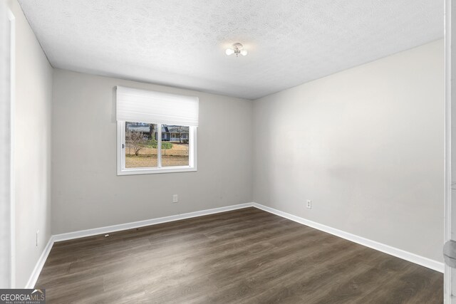 empty room featuring dark hardwood / wood-style floors and a textured ceiling