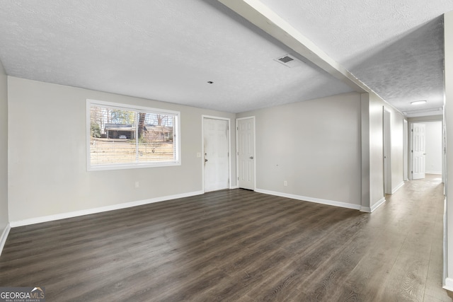 unfurnished living room with dark wood-type flooring and a textured ceiling