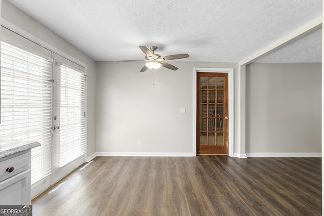 unfurnished room featuring dark hardwood / wood-style flooring, ceiling fan, and a textured ceiling