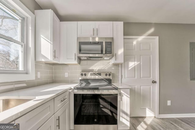 kitchen with plenty of natural light, stainless steel appliances, and white cabinets