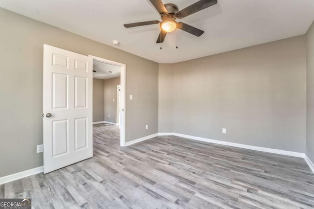 empty room with ceiling fan and light hardwood / wood-style floors