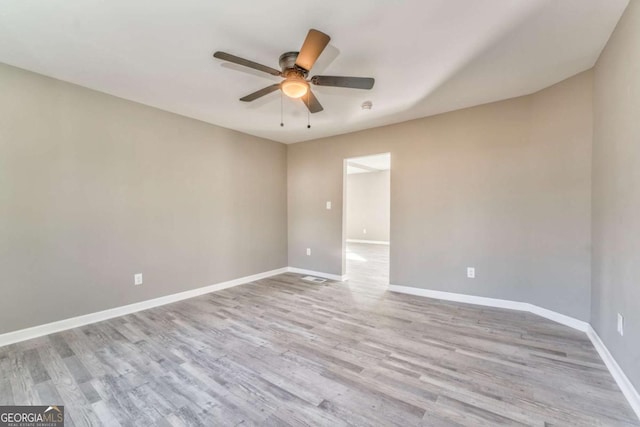 empty room with ceiling fan and light hardwood / wood-style floors