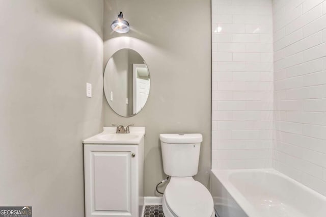 full bathroom featuring tiled shower / bath, vanity, and toilet