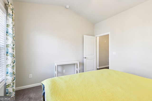 unfurnished bedroom featuring lofted ceiling and carpet