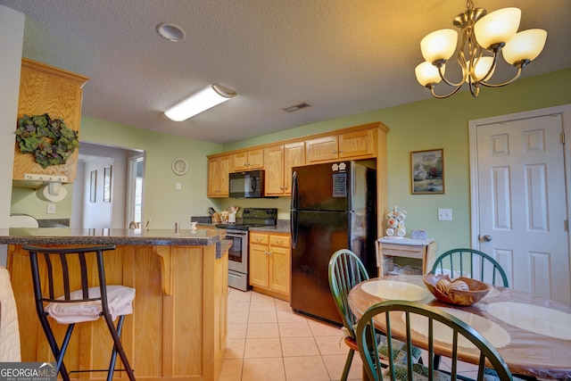 kitchen featuring a breakfast bar, hanging light fixtures, light tile patterned floors, kitchen peninsula, and black appliances