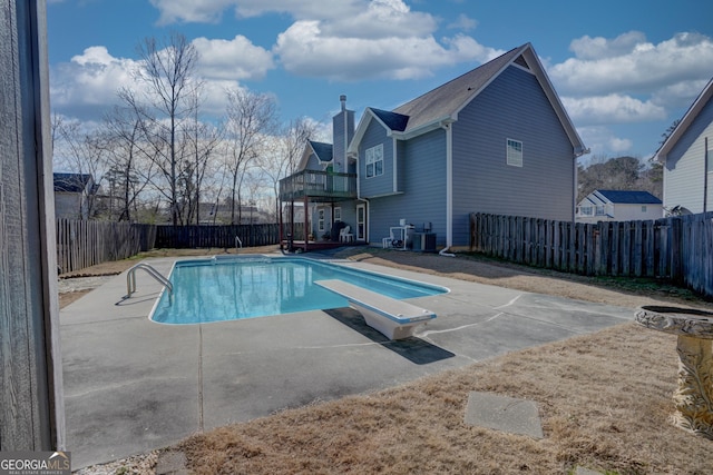 view of swimming pool with a diving board and a patio area