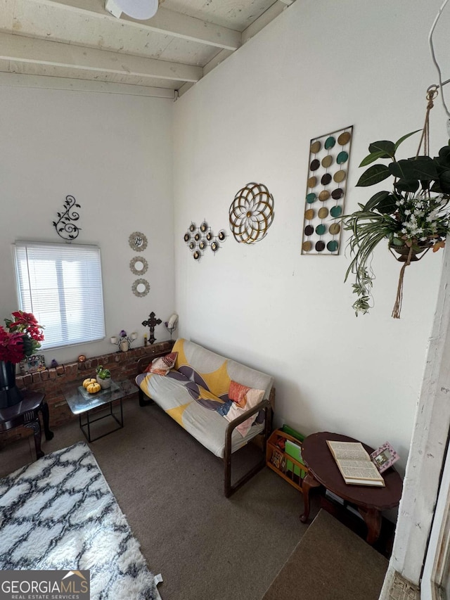 carpeted living room with beam ceiling