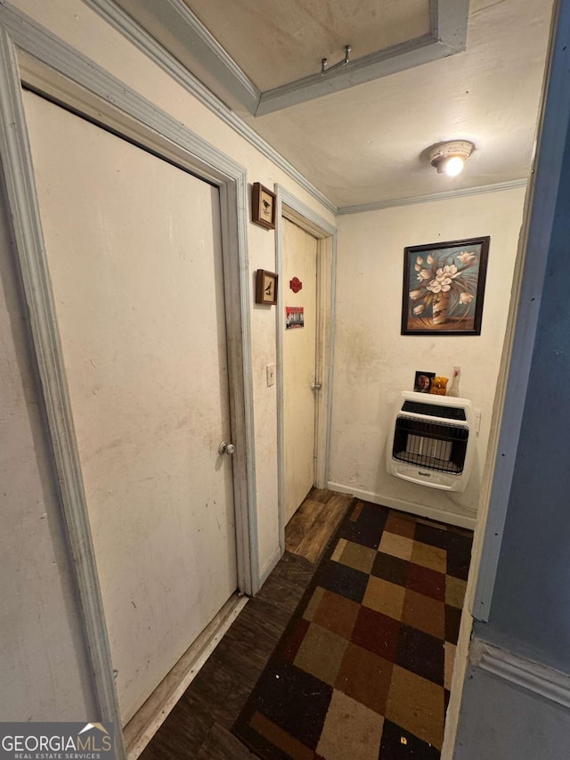 hallway with crown molding, dark wood-type flooring, and heating unit