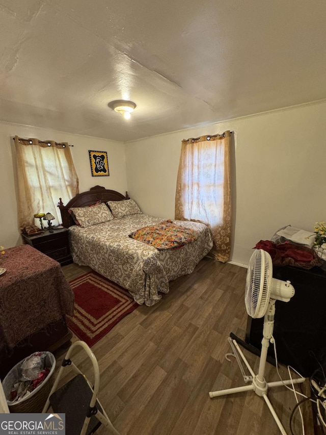 bedroom with dark hardwood / wood-style flooring