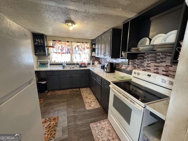 kitchen featuring sink, white appliances, backsplash, dark hardwood / wood-style floors, and a textured ceiling