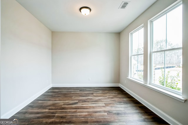 empty room with dark hardwood / wood-style flooring