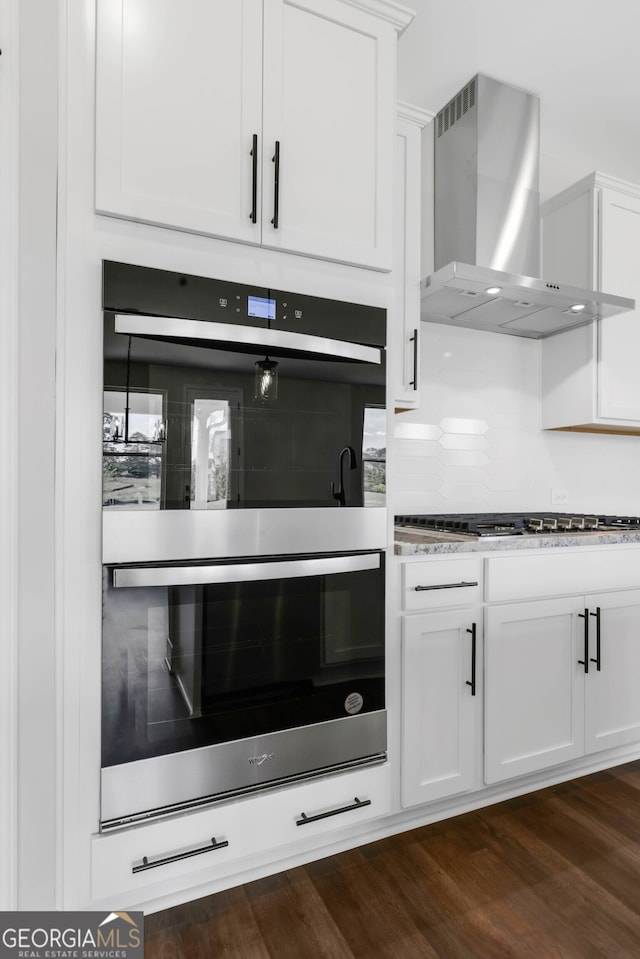 39 Pecan Ct, Hoschton, GA 30548 - kitchen featuring wall chimney exhaust hood, appliances with stainless steel finishes, white cabinets, decorative backsplash, and dark wood-style flooring