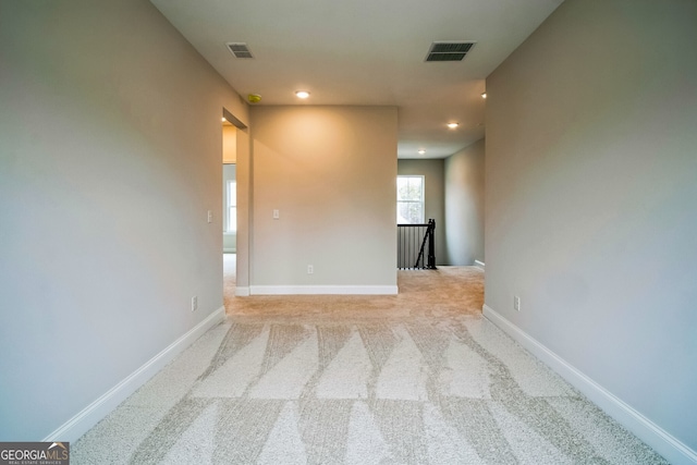 unfurnished room featuring light carpet