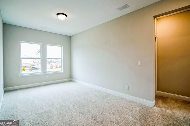 unfurnished room featuring light carpet