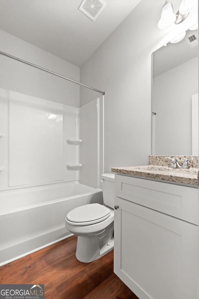 full bathroom with hardwood / wood-style flooring,  shower combination, toilet, and vanity