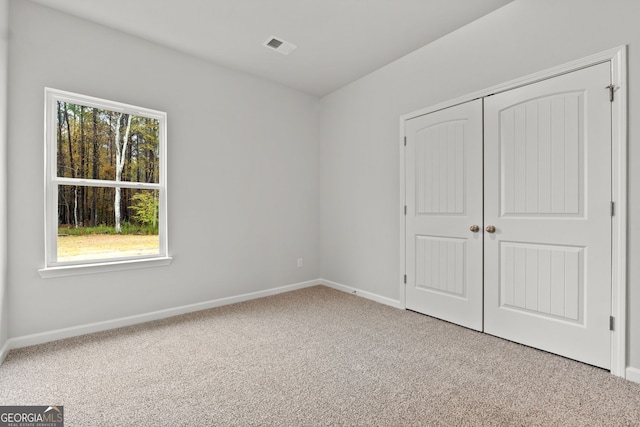 unfurnished bedroom with carpet flooring and a closet