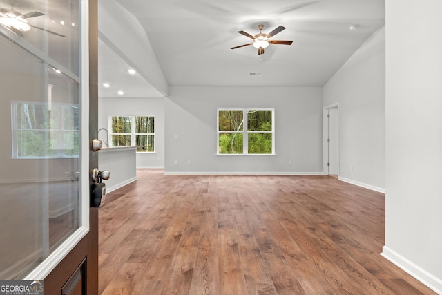 empty room featuring lofted ceiling, hardwood / wood-style floors, and ceiling fan