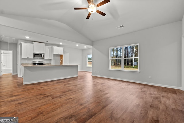 unfurnished living room featuring ceiling fan, dark hardwood / wood-style floors, and vaulted ceiling