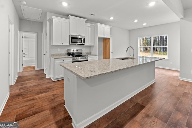 kitchen with white cabinetry, appliances with stainless steel finishes, a kitchen island with sink, and sink