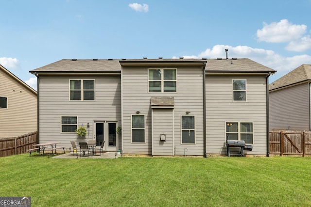 rear view of house with a patio, a yard, and french doors