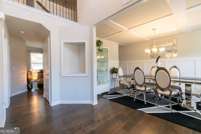 dining area featuring coffered ceiling, dark hardwood / wood-style floors, and a chandelier