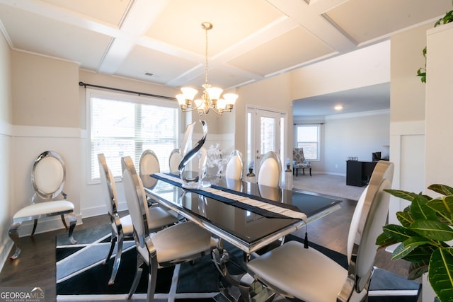 dining room with coffered ceiling, crown molding, dark wood-type flooring, and a chandelier