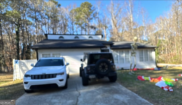 view of front facade featuring concrete driveway and a front yard