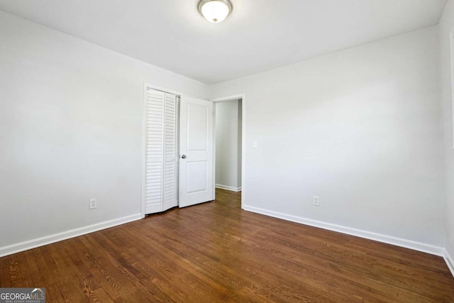6467 Joanna St, Lithia Springs, GA 30122 - unfurnished bedroom featuring baseboards, a closet, and dark wood-style floors