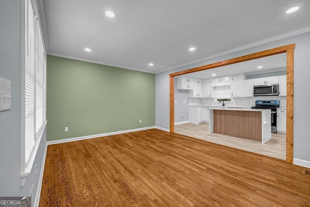 6467 Joanna St, Lithia Springs, GA 30122 - unfurnished living room featuring crown molding, recessed lighting, and light wood-style floors