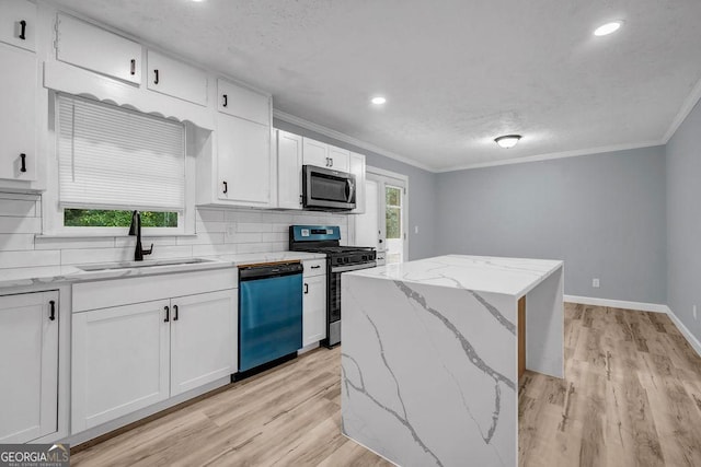 6467 Joanna St, Lithia Springs, GA 30122 - kitchen featuring appliances with stainless steel finishes, ornamental molding, white cabinets, light wood finished floors, and backsplash
