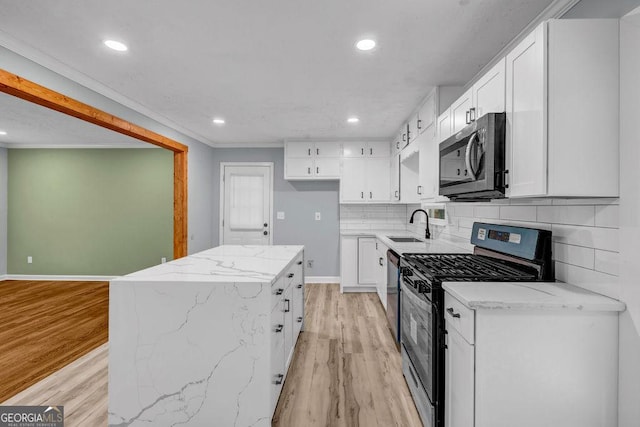 6467 Joanna St, Lithia Springs, GA 30122 - kitchen with appliances with stainless steel finishes, light wood finished floors, white cabinets, recessed lighting, and a kitchen island
