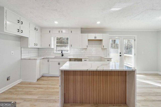 6467 Joanna St, Lithia Springs, GA 30122 - kitchen with baseboards, tasteful backsplash, a sink, white cabinets, and light wood-style flooring
