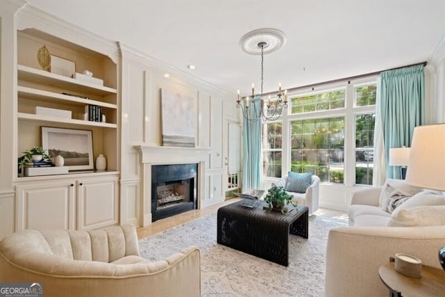 living room featuring a notable chandelier, crown molding, and built in features