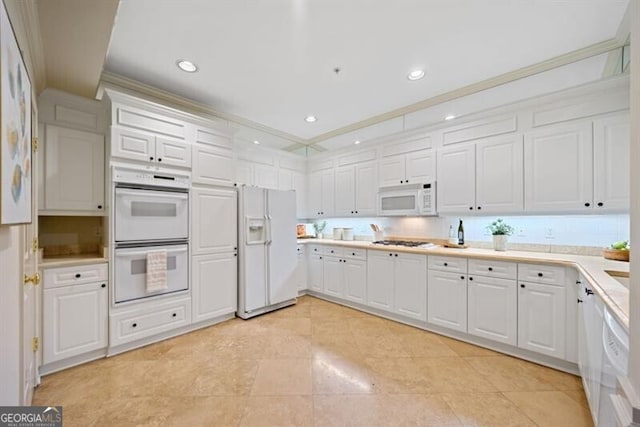 kitchen with white cabinetry, crown molding, and white appliances