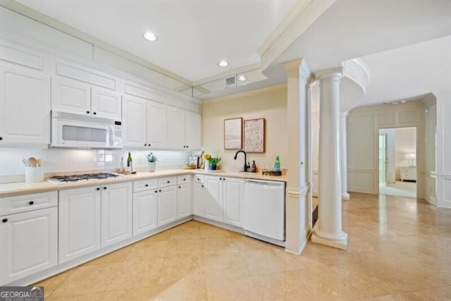 kitchen with ornate columns, white cabinetry, decorative backsplash, ornamental molding, and white appliances