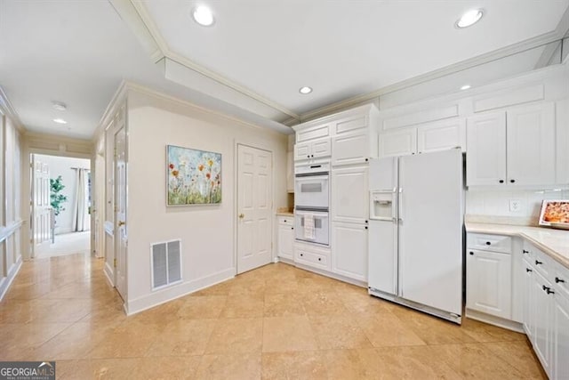 kitchen featuring crown molding, white appliances, backsplash, and white cabinets