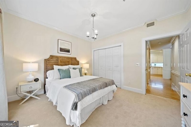 bedroom featuring ornamental molding, light colored carpet, a closet, and a chandelier