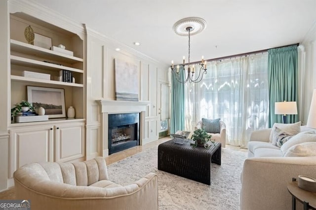 living room featuring built in shelves, crown molding, and a chandelier