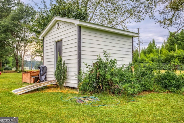 view of outbuilding with a lawn