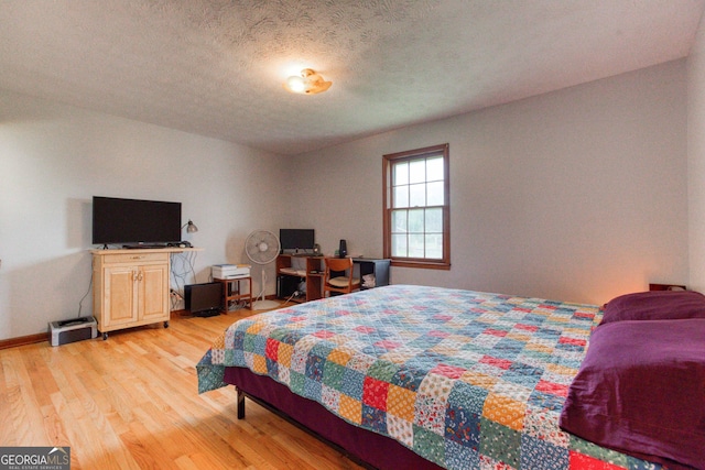 bedroom featuring light hardwood / wood-style flooring and a textured ceiling