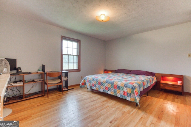 bedroom featuring light hardwood / wood-style flooring and a textured ceiling