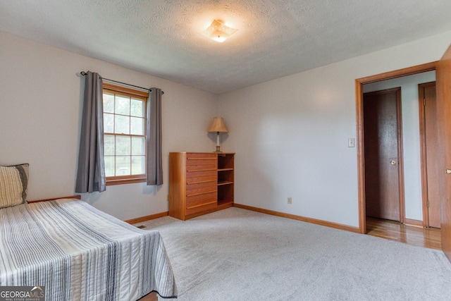 unfurnished bedroom with light colored carpet and a textured ceiling