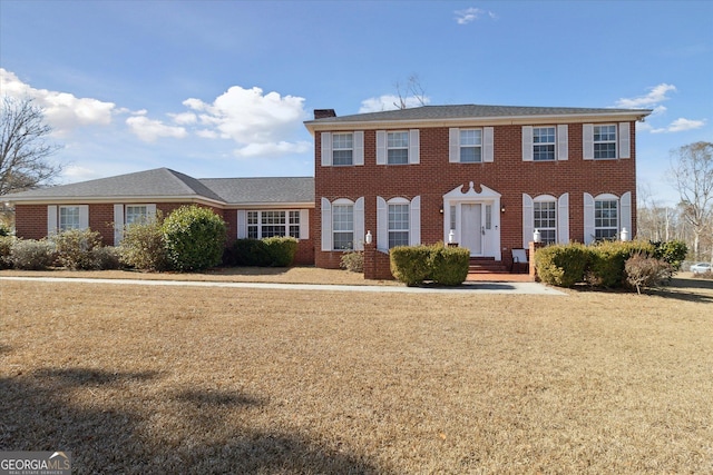 colonial-style house with a front lawn