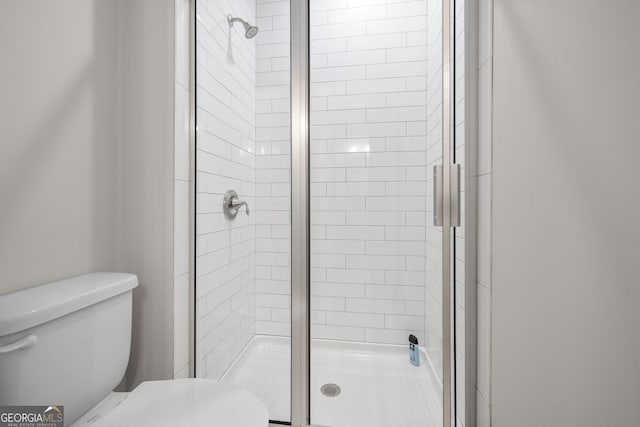 bathroom featuring an enclosed shower and toilet