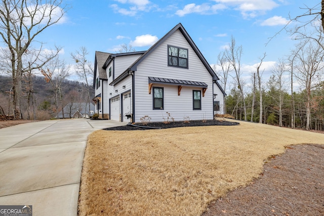 view of side of property featuring a garage and a lawn